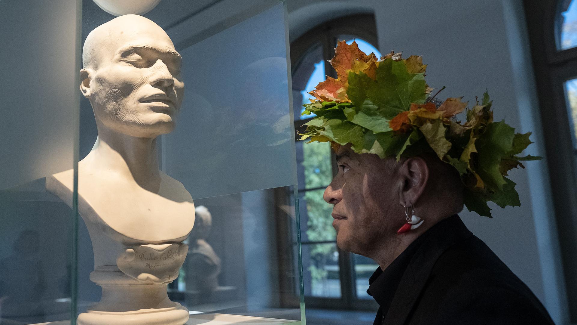 Te Herekiekie Herewini vom Museum of New Zealand Te Papa Tongarewa steht an einer Maori-Büste im "Forum Wissen" der Universität Göttingen. Te Herekiekie Herewini vom Museum of New Zealand Te Papa Tongarewa steht an einer Maori-Büste im "Forum Wissen" der Universität Göttingen.