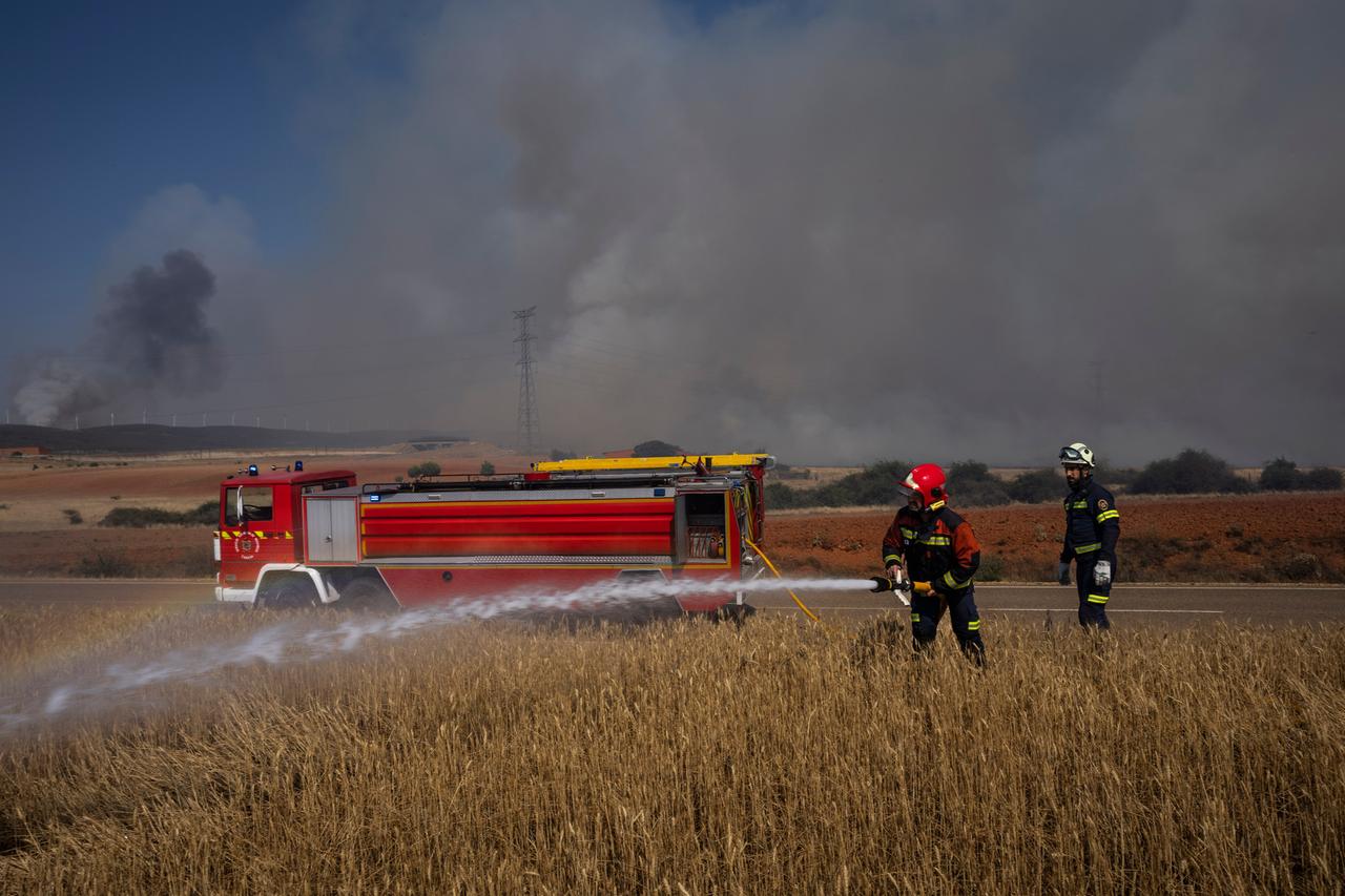 Feuerwehrleute beim Einsatz in einem Feld in Nordwestspanien Feuerwehrleute beim Einsatz in einem Feld in Nordwestspanien