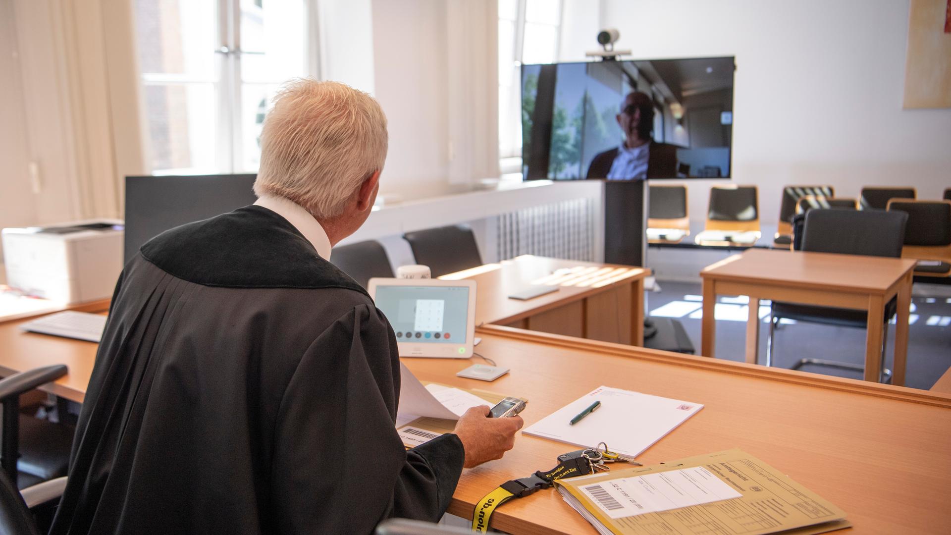 Über einen Monitor per Video zugeschaltet ist ein Rechtsanwalt während einer Verhandlung am Amtsgericht in Frankfurt am Main. Dabei kann der vorsitzende Richter die Kamera am Monitor per Fernbedienung so drehen, dass auch der zugeschaltete Anwalt die Verfahrensbeteiligten sehen kann. Über einen Monitor per Video zugeschaltet ist ein Rechtsanwalt während einer Verhandlung am Amtsgericht in Frankfurt am Main. Dabei kann der vorsitzende Richter die Kamera am Monitor per Fernbedienung so drehen, dass auch der zugeschaltete Anwalt die Verfahrensbeteiligten sehen kann.