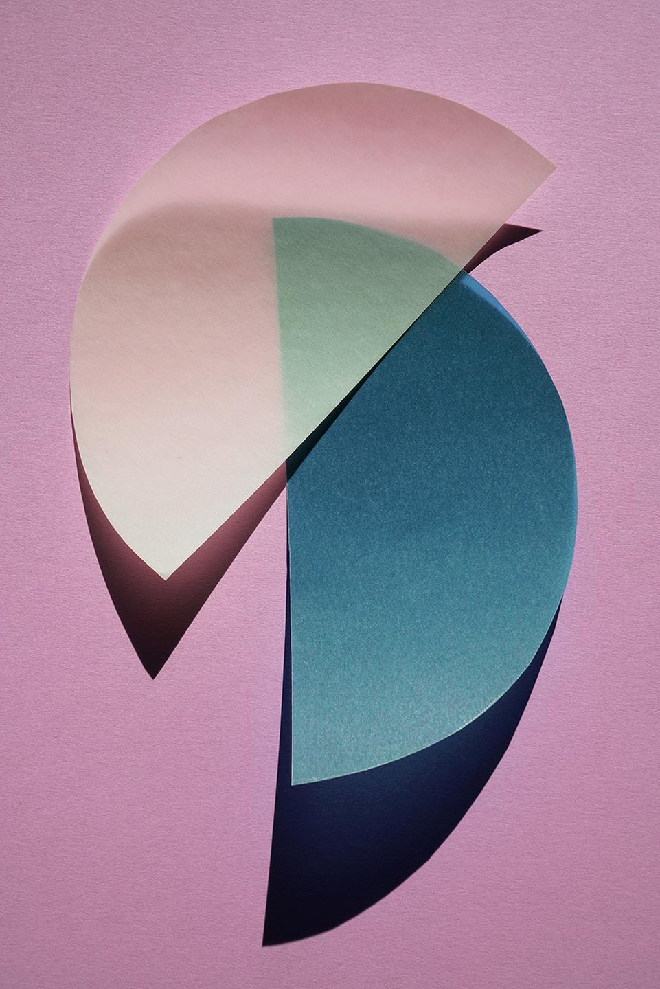 Ein blauer und ein gelber Halbkreis aus Papier vor rosa Hintergrund. Ein blauer und ein gelber Halbkreis aus Papier vor rosa Hintergrund.