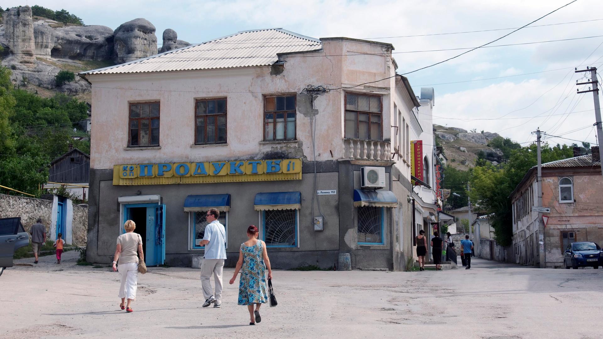 Ein Platz in dem Ort Bachtschyssaraj auf der Halbinsel Krim, die 2014 von Russland annektiert wurde. Das Foto wurde im Spätsommer 2011 aufgenommen. Mehrere Fußgänger überqueren den Platz. Im Hintergrund sind Felsen und Hügel zu sehen. Ein Platz in dem Ort Bachtschyssaraj auf der Halbinsel Krim, die 2014 von Russland annektiert wurde. Das Foto wurde im Spätsommer 2011 aufgenommen. Mehrere Fußgänger überqueren den Platz. Im Hintergrund sind Felsen und Hügel zu sehen.