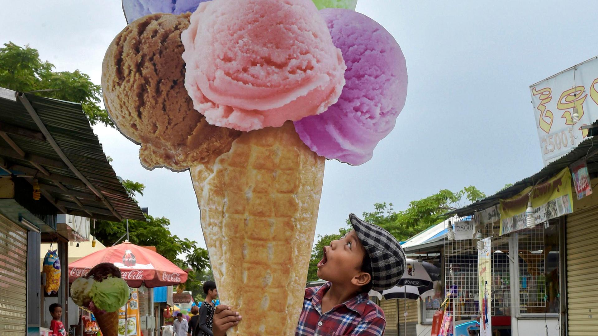 Ein Junge umarmt übergrosse Eiscreme aus Pappe. Ein Junge umarmt übergrosse Eiscreme aus Pappe.