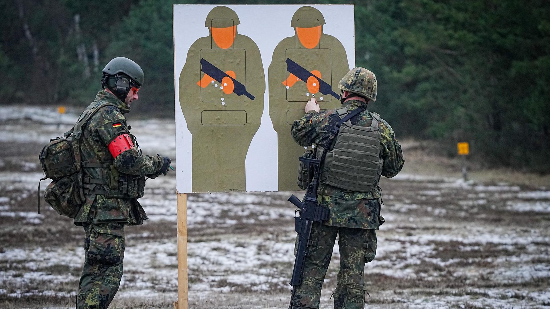 Zwei Bundeswehrsoldaten trainieren mit dem G36-Gewehr auf einem Truppenübungsplatz mit Pappsoldaten als Zielscheibe. 