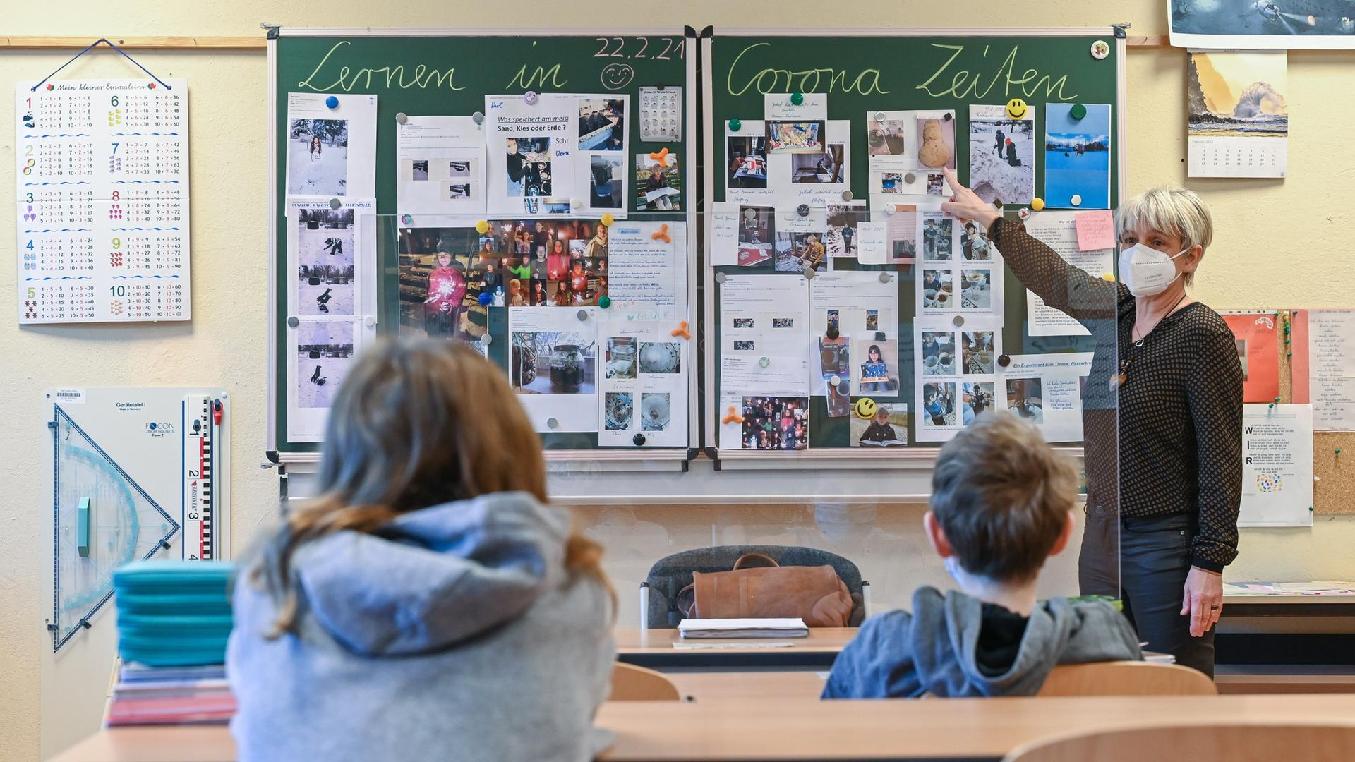 Die Lehrerin einer 4. Klasse an der Grundschule "Am Mühlenfließ" in Frankfurt (Oder), unterrichtet zwei SchülerInnen in einem Klassenzimmer. Auf der Tafal steht "Lernen in Corona Zeiten". Die Lehrerin einer 4. Klasse an der Grundschule "Am Mühlenfließ" in Frankfurt (Oder), unterrichtet zwei SchülerInnen in einem Klassenzimmer. Auf der Tafal steht "Lernen in Corona Zeiten".