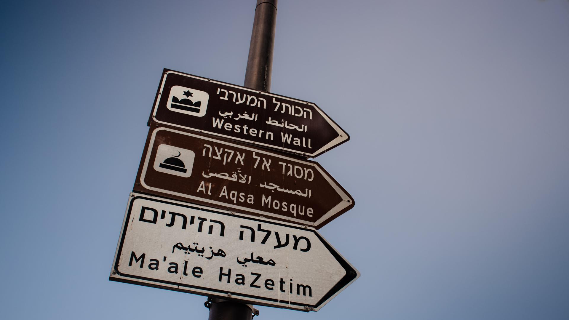Schilder, die den Weg Richtung Al-Aksa-Moschee und der Klagemauer in Jerusalem weisen, vor blauem Himmel