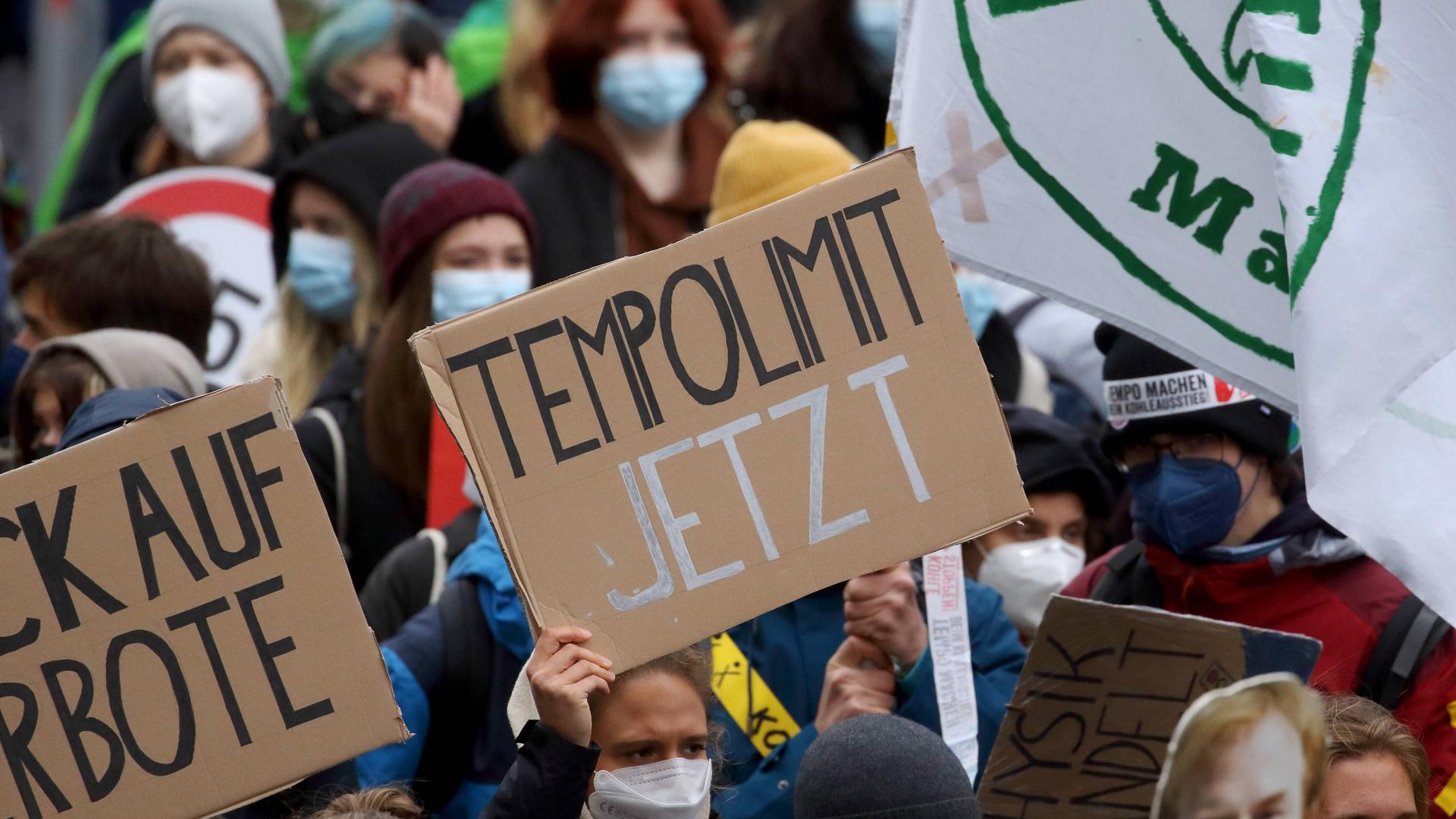 Ein Demoteilnehmer hält ein Plakat mit der Aufschrift "Tempolimit Jetzt" in die Höhe. Ein Demoteilnehmer hält ein Plakat mit der Aufschrift "Tempolimit Jetzt" in die Höhe.