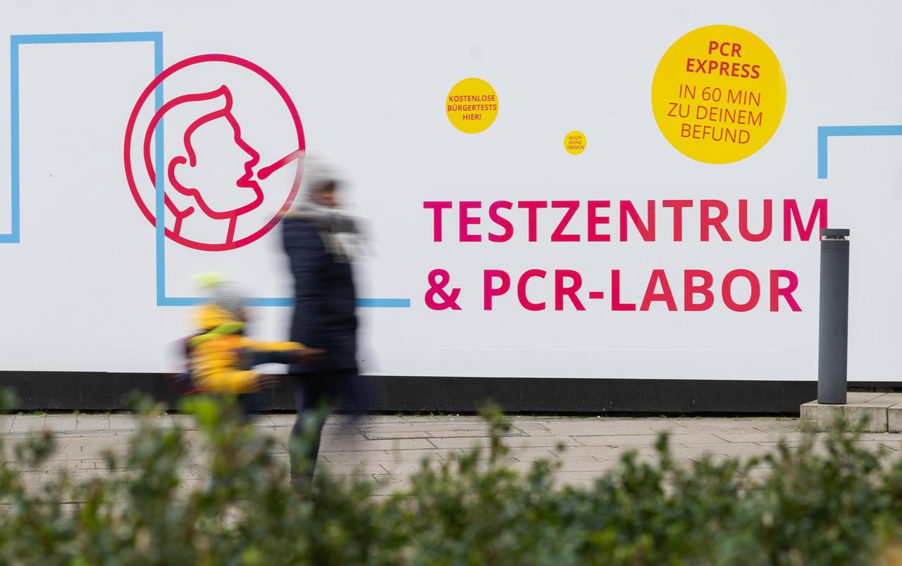 Eine Frau und ein Kind laufen in Hannover an einem Testzentrum für das Corona-Virus vorbei Eine Frau und ein Kind laufen in Hannover an einem Testzentrum für das Corona-Virus vorbei