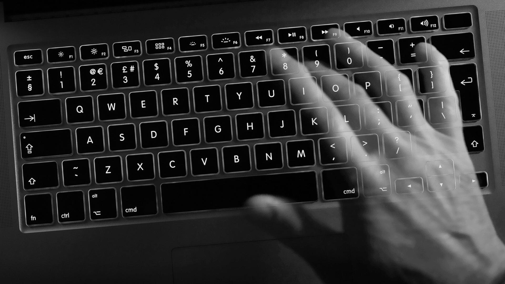 Eine Hand schreibt auf einer Computertastatur. Eine Hand schreibt auf einer Computertastatur.