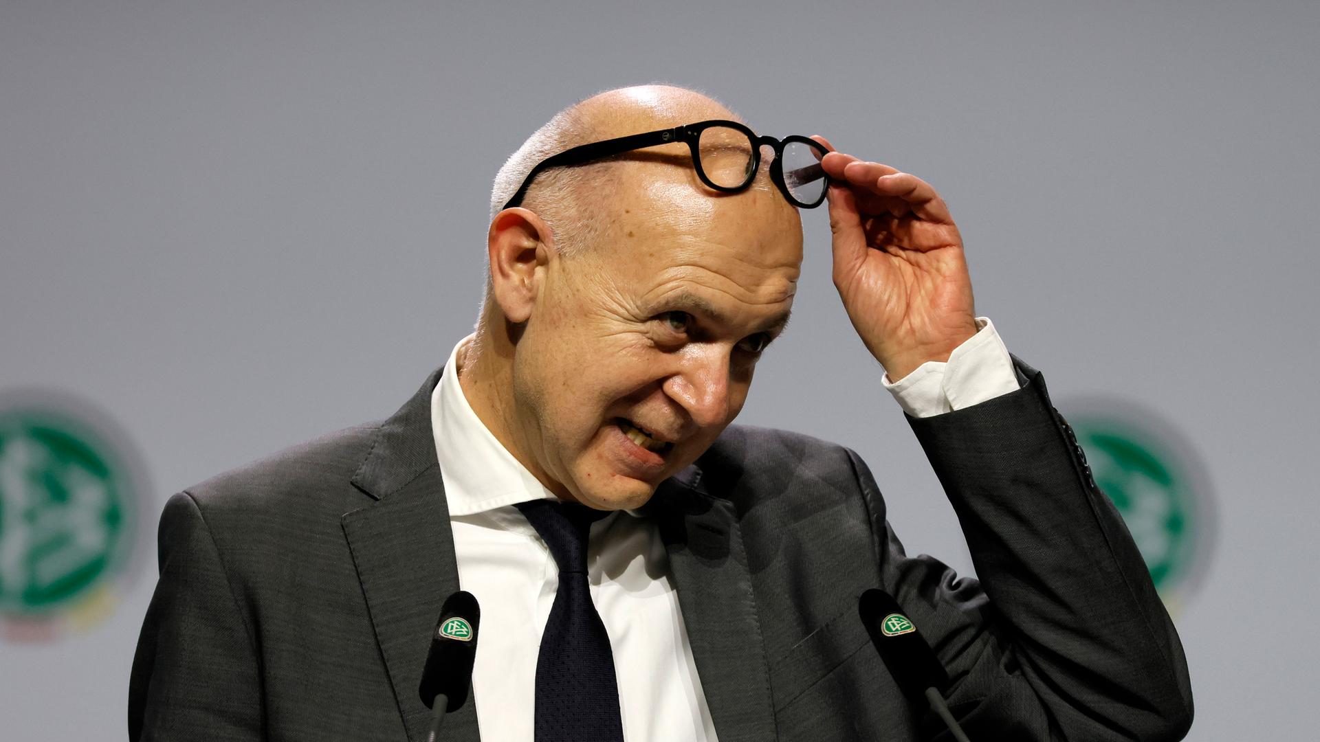 Neuendorf steht auf der Bühne beim DFB-Bundestag und schiebt seine Brille auf die Stirn. Neuendorf steht auf der Bühne beim DFB-Bundestag und schiebt seine Brille auf die Stirn.