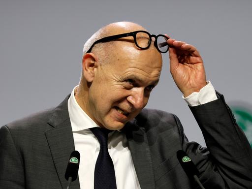 Neuendorf steht auf der Bühne beim DFB-Bundestag und schiebt seine Brille auf die Stirn.