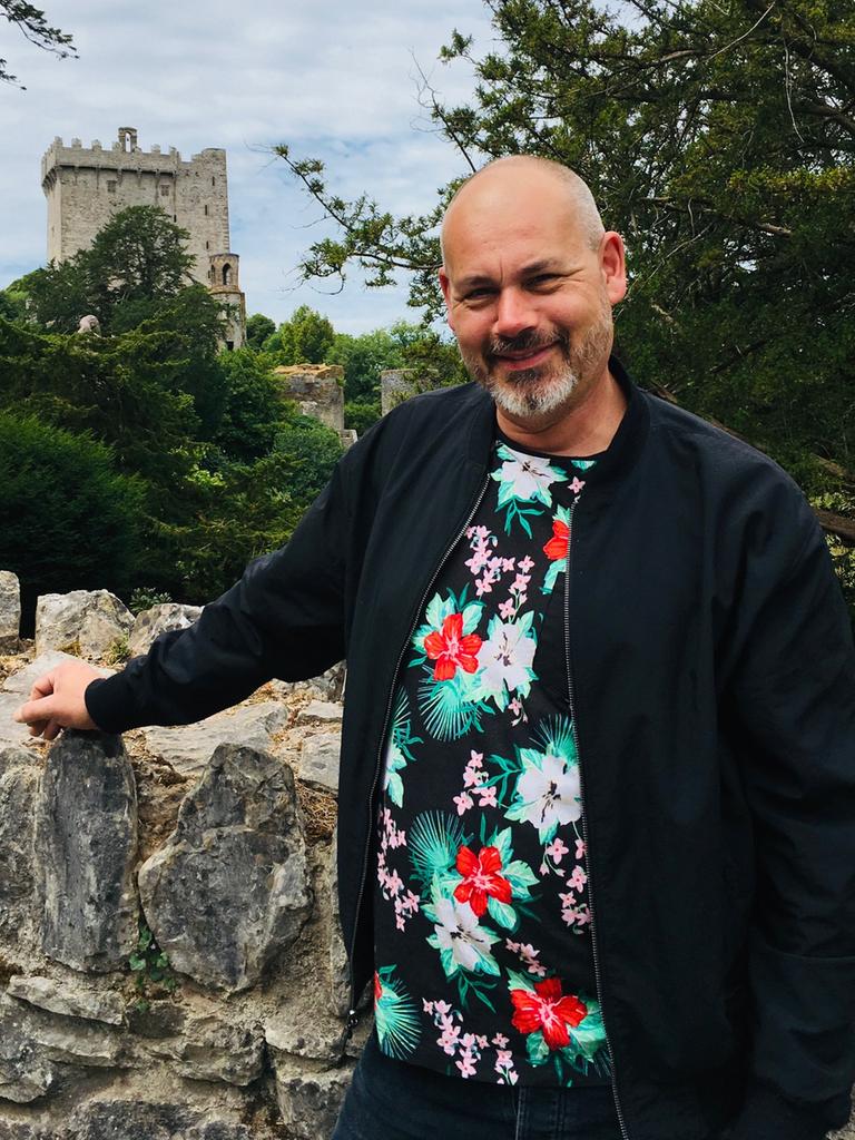 Alfons Mühlenbrock steht mit dem Arm an eine Mauer gestützt. Im Hintergrund ist der Turm einer Burg erkennbar. Alfons Mühlenbrock steht mit dem Arm an eine Mauer gestützt. Im Hintergrund ist der Turm einer Burg erkennbar.
