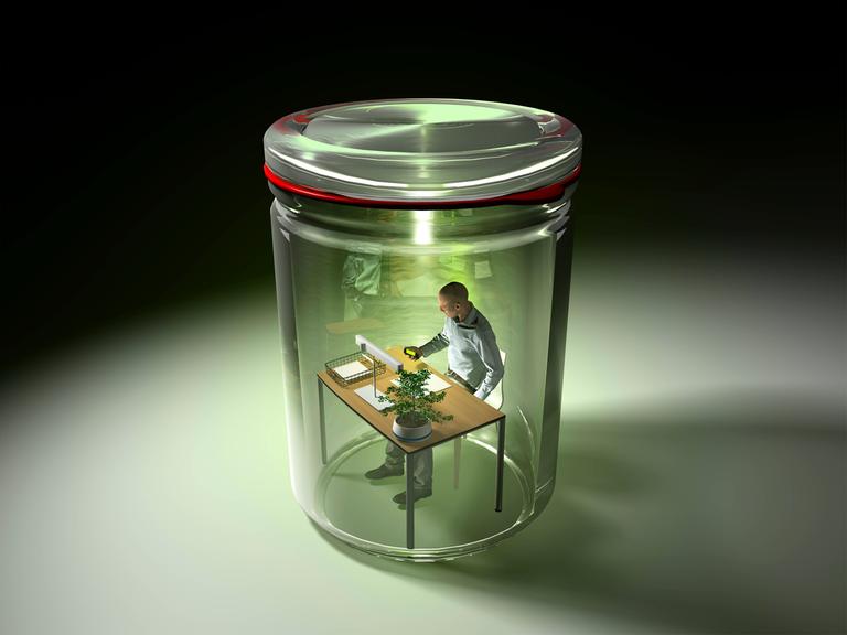 Fotomontage eines Mannes an einem Schreibtisch, eingesperrt in einem Einmachglas.