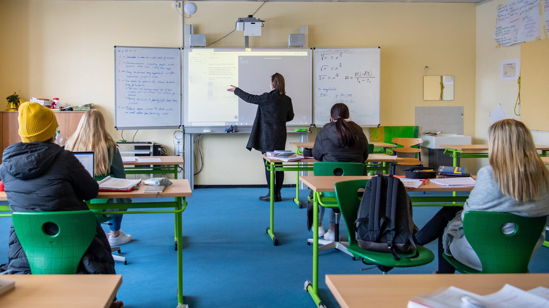Eine Lehrerin steht an der Tafel. Eine Lehrerin steht an der Tafel.