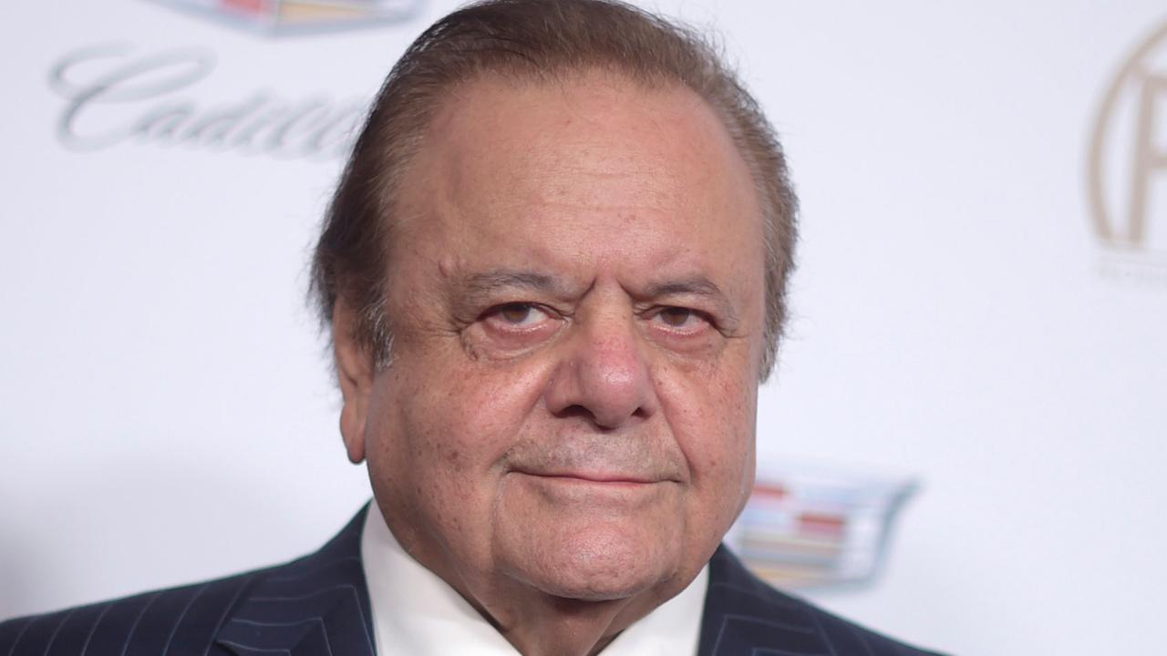 Paul Sorvino trägt einen Anzug, ein weißes Hemd und eine rote Krawatte. Paul Sorvino trägt einen Anzug, ein weißes Hemd und eine rote Krawatte.