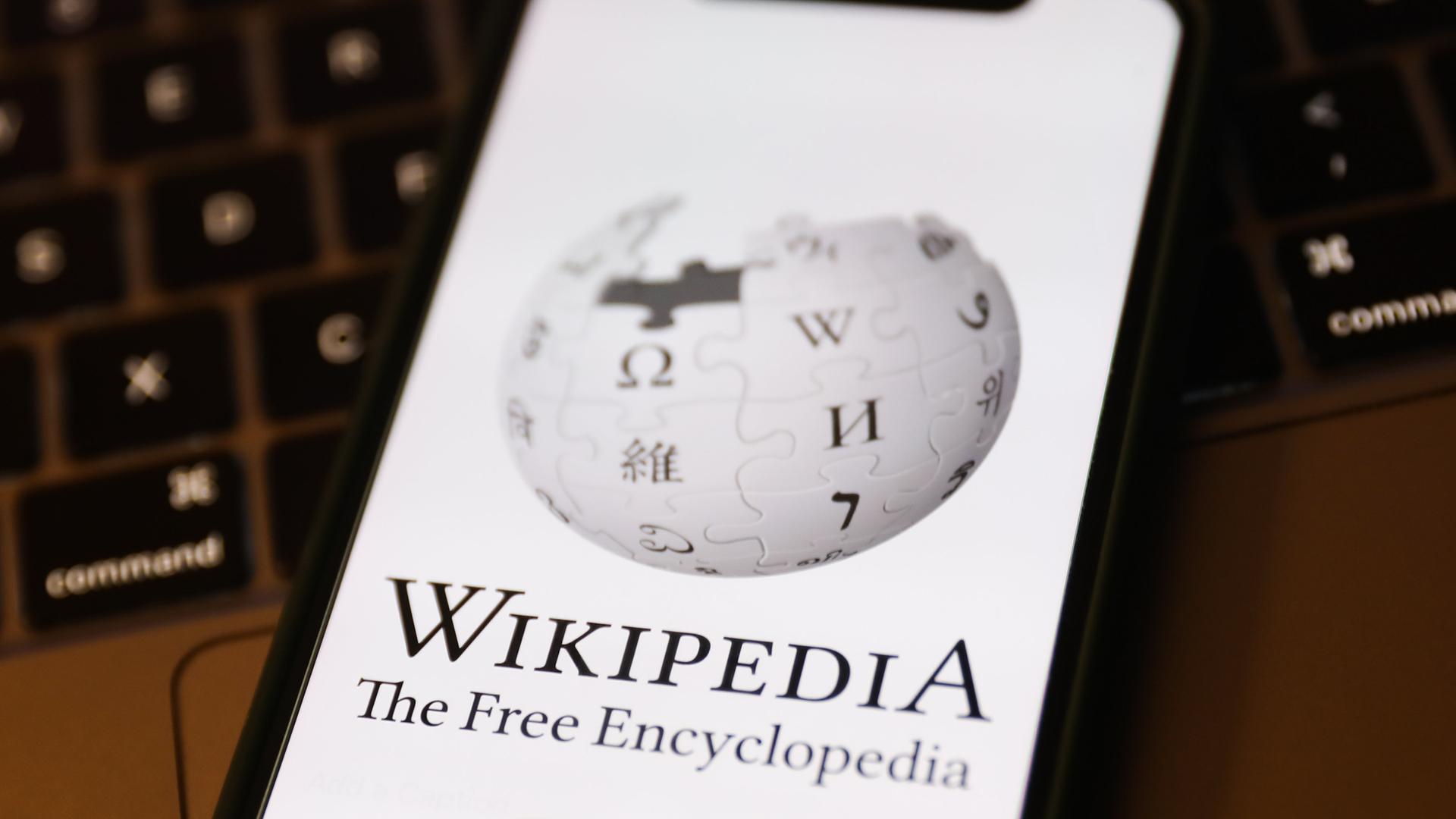 Das Logo der Online-Enzyklopädie Wikipedia ist auf einem Mobiltelefon zu sehen.