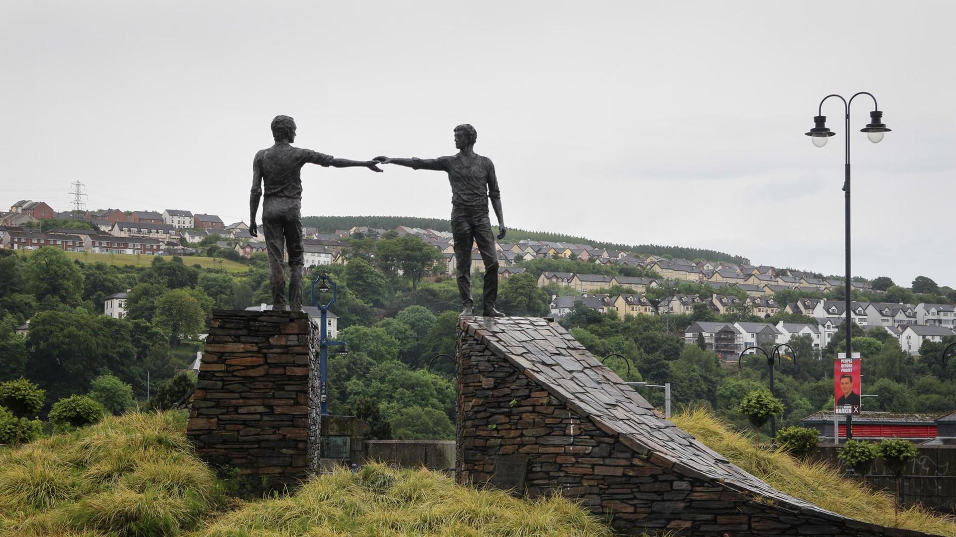 Die Skulptur "Hands Across the Divide" von Maurice Harron steht auf einem Hügel bei Derry, Nordirland. Die Skulptur "Hands Across the Divide" von Maurice Harron steht auf einem Hügel bei Derry, Nordirland.
