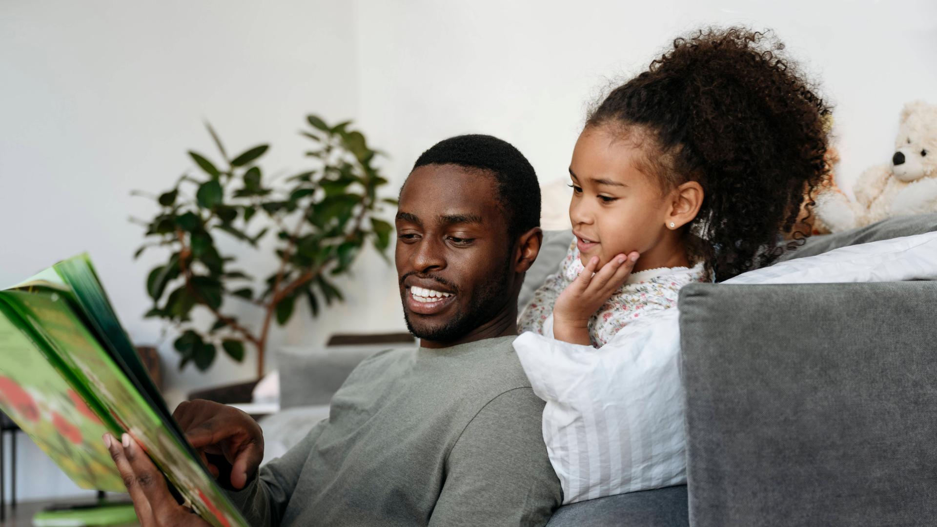 Young man telling story to daughter in living room model released property released, VYF00604 Young man telling story to daughter in living room model released property released, VYF00604