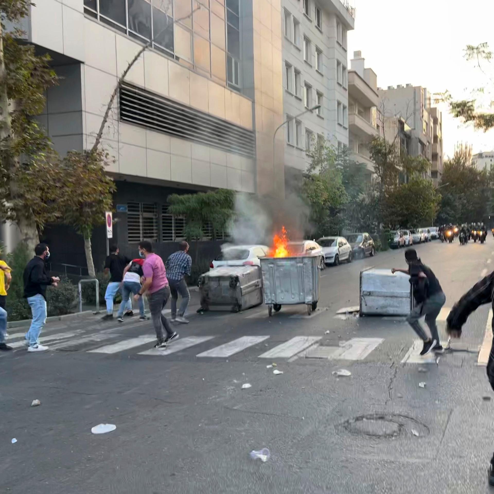 Iran, Teheran: Demonstranten werfen während eines Protestes gegen den Tod einer jungen Frau, die wegen eines Verstoßes gegen die konservative Kleiderordnung des Landes inhaftiert worden war, Steine auf die Polizeieinheiten.
