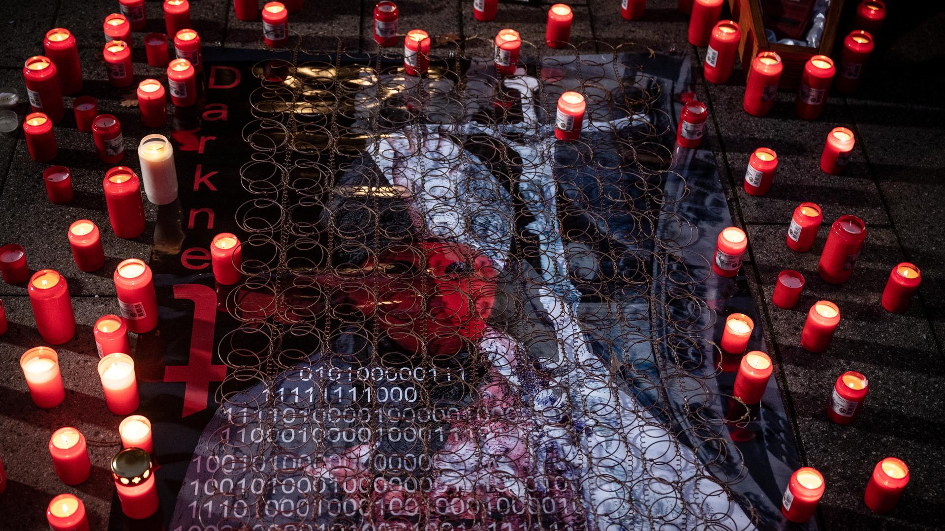 Teilnehmende einer Protestkundgebung haben an einem stilisierten Bild eines Geistlichen Kerzen für die Opfer von sexuellem Missbrauch in der Kirche entzündet. Teilnehmende einer Protestkundgebung haben an einem stilisierten Bild eines Geistlichen Kerzen für die Opfer von sexuellem Missbrauch in der Kirche entzündet.