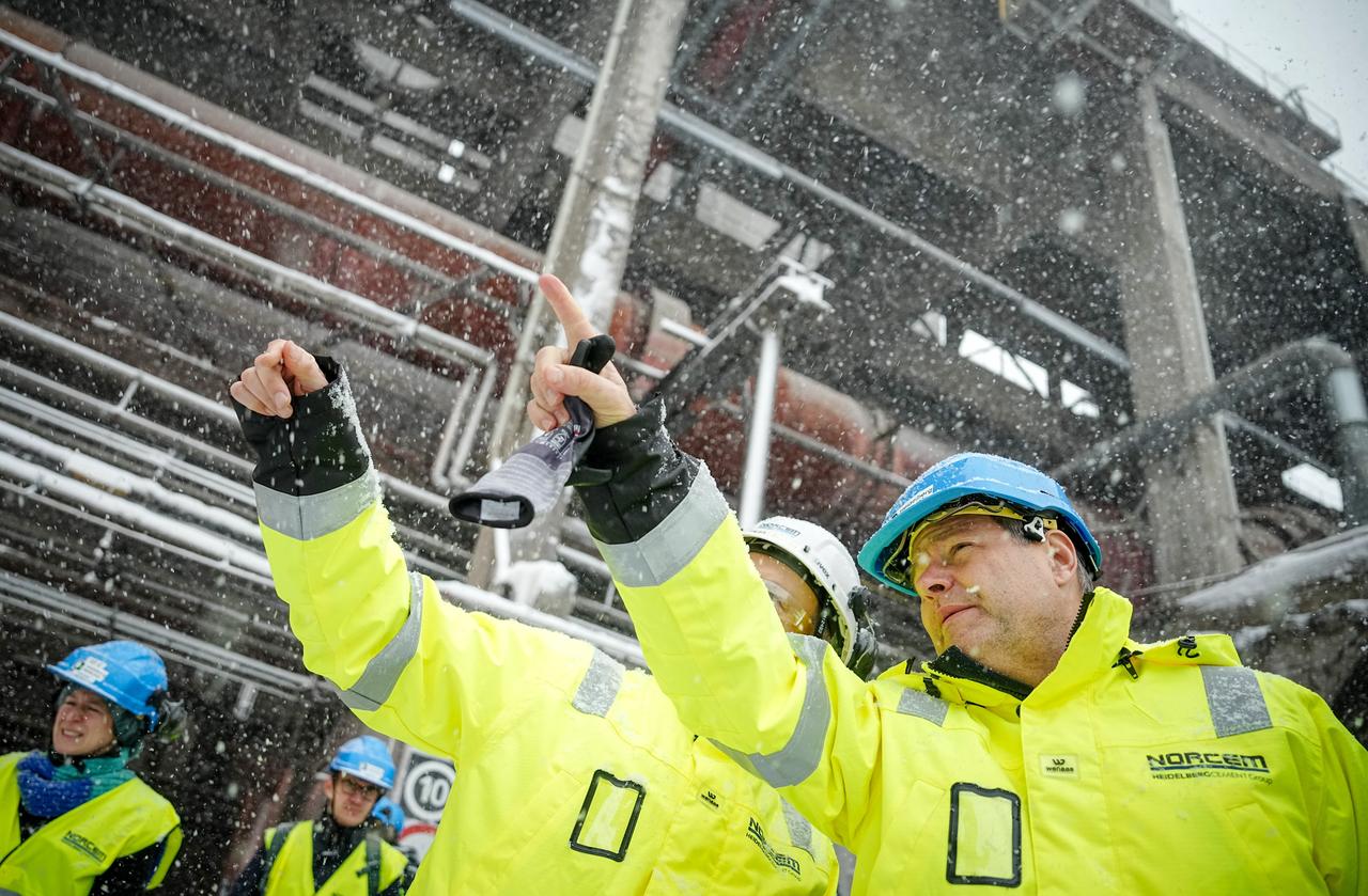 Robert Habeck (r, Bündnis 90/Die Grünen), Bundesminister für Wirtschaft und Klimaschutz, im dichten Schneetreiben beim norwegischen Unternehmen Norcem