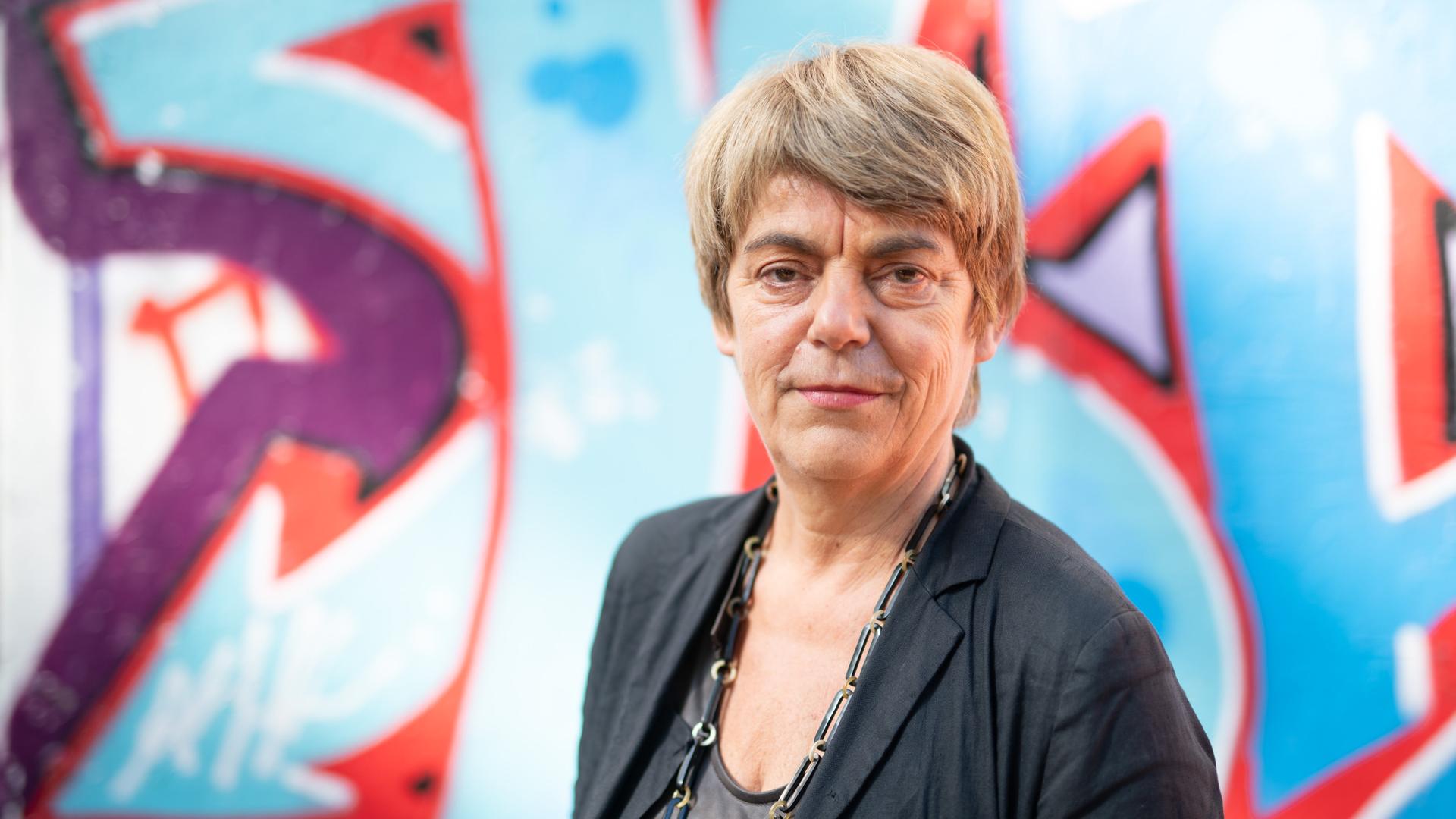Amelie Deuflhard, die Intendantin der Kulturfabrik Kampnagel, steht vor einer mit Graffiti besprüh
ten Wand und blickt in die Kamera Amelie Deuflhard, die Intendantin der Kulturfabrik Kampnagel, steht vor einer mit Graffiti besprüh
ten Wand und blickt in die Kamera
