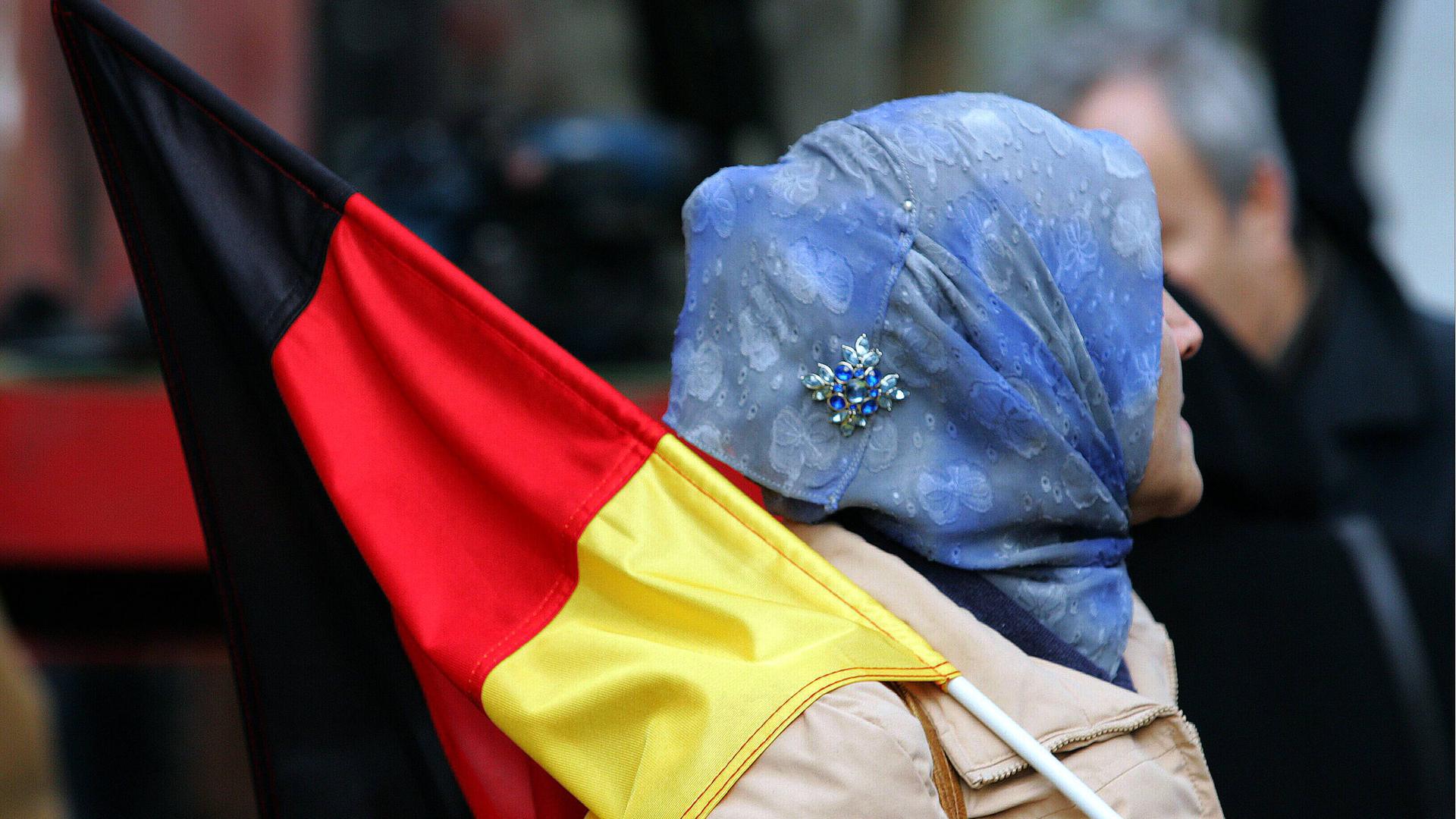 Muslima mit Kopftuch trägt eine Deutschlandfahne auf der Demonstration: MUSLIME GEMEINSAM FÜR FRIEDEN GEGEN TERROR in Köln (2004)