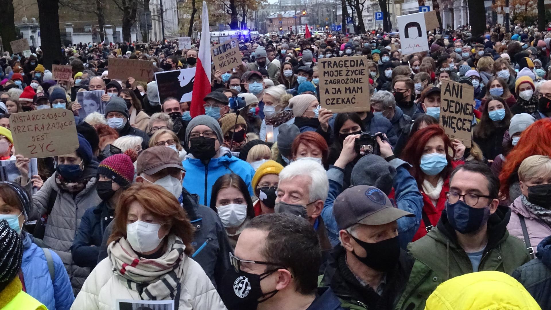 Tausende Menschen mit Plakaten auf einer Straße, dicht gedrängt, mit Masken. Tausende Menschen mit Plakaten auf einer Straße, dicht gedrängt, mit Masken.
