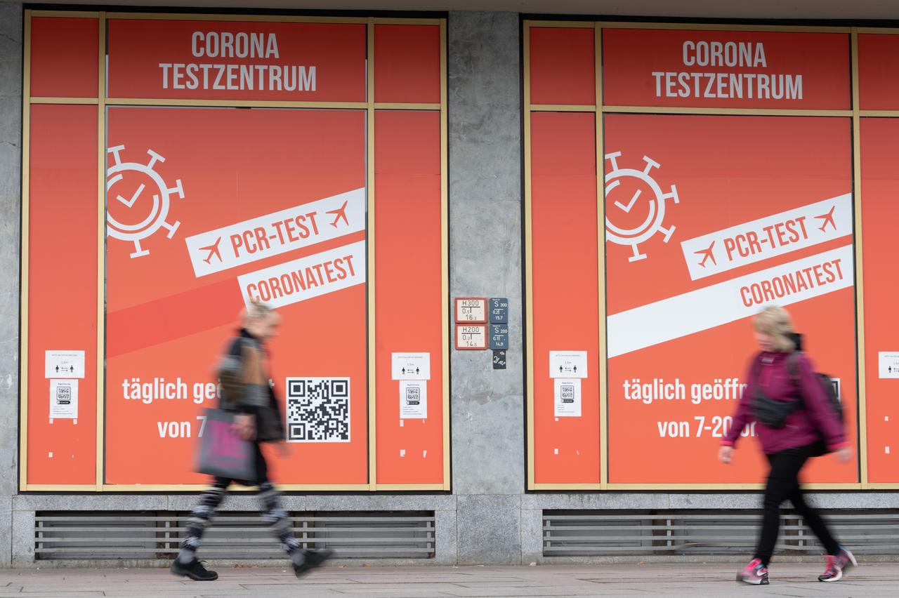 Passanten gehen vor einem Corona-Testzentrum entlang. Passanten gehen vor einem Corona-Testzentrum entlang.