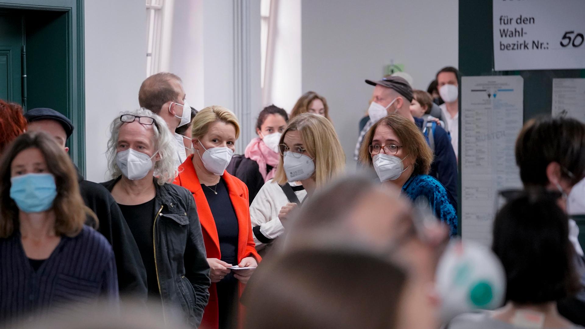 In eine Wahllokal stehen viele Menschen Schlange, darunter Franziska Giffey. Die Menschen tragen Masken zum Schutz vor der Ansteckung mit Corona. In eine Wahllokal stehen viele Menschen Schlange, darunter Franziska Giffey. Die Menschen tragen Masken zum Schutz vor der Ansteckung mit Corona.