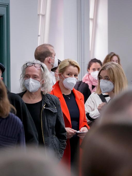 In eine Wahllokal stehen viele Menschen Schlange, darunter Franziska Giffey. Die Menschen tragen Masken zum Schutz vor der Ansteckung mit Corona.