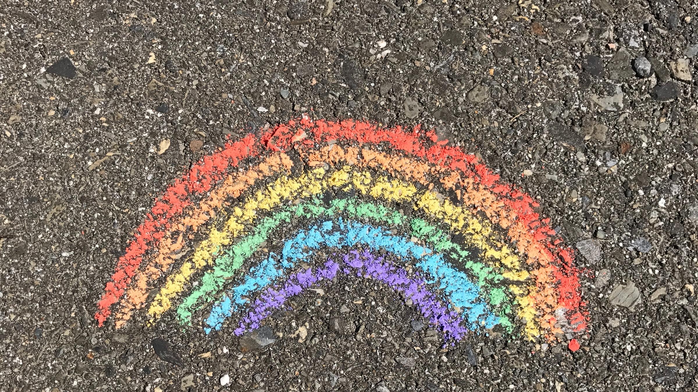 Ein Regenbogen mit Kreide auf den Asphalt gemalt. Ein Regenbogen mit Kreide auf den Asphalt gemalt.