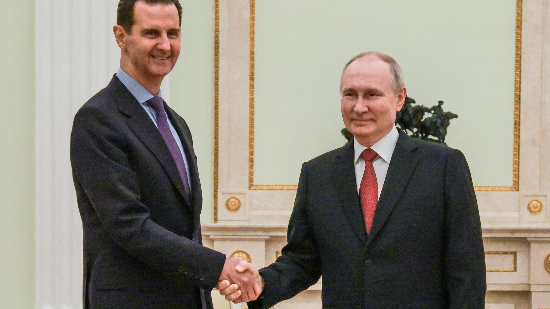 Russlands Präsident Wladimir Putin (r) und der syrische Machthaber Baschar al-Assad schütteln sich bei einem Besuch Assads in Moskau die Hände.