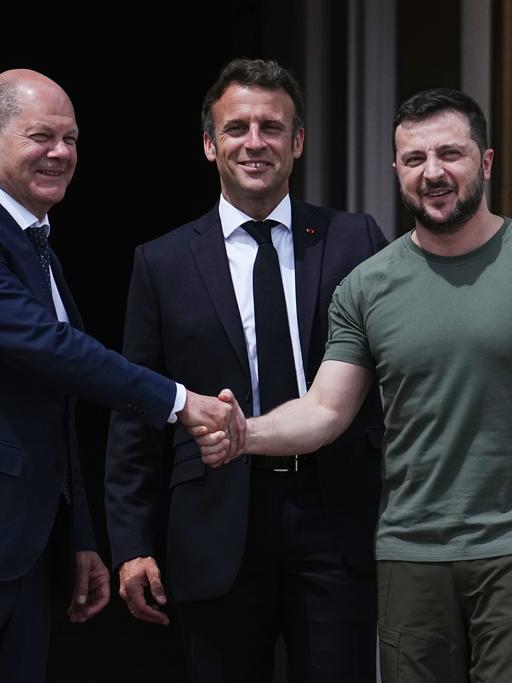Wolodymyr Selenskyj (r), Präsident der Ukraine, begrüßt Bundeskanzler Olaf Scholz (l, SPD) und Emmanuel Macron (M), Präsident von Frankreich. 