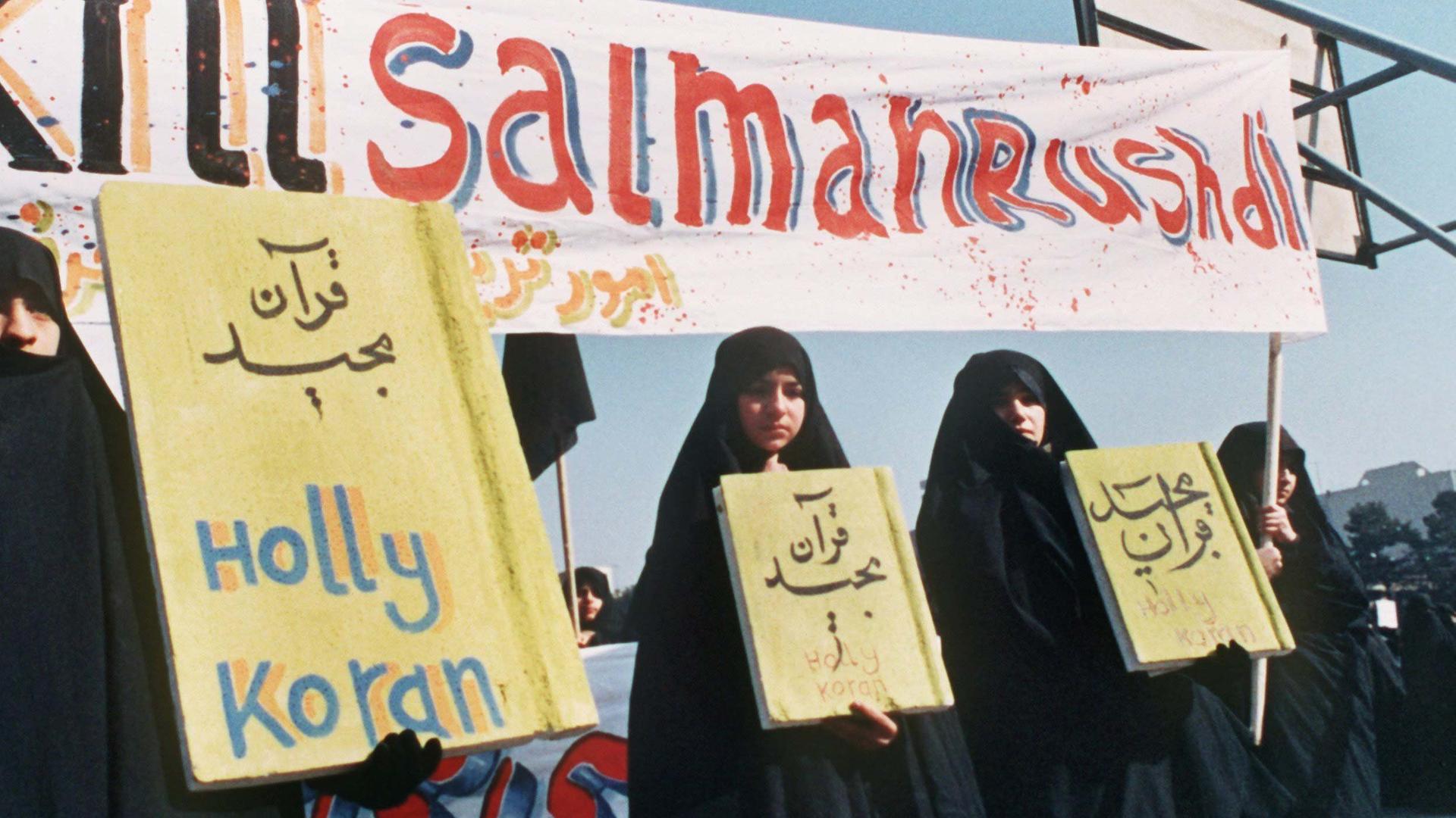 Kill Salman Rushdie" ist auf einem Spruchband zu lesen, das iranische Frauen (Archivbild vom 17.2.1989) in Teheran bei einer Demonstration gegen den britischen Schriftsteller Salman Rushdie und sein Buch "Satanische Verse" mit sich führen 