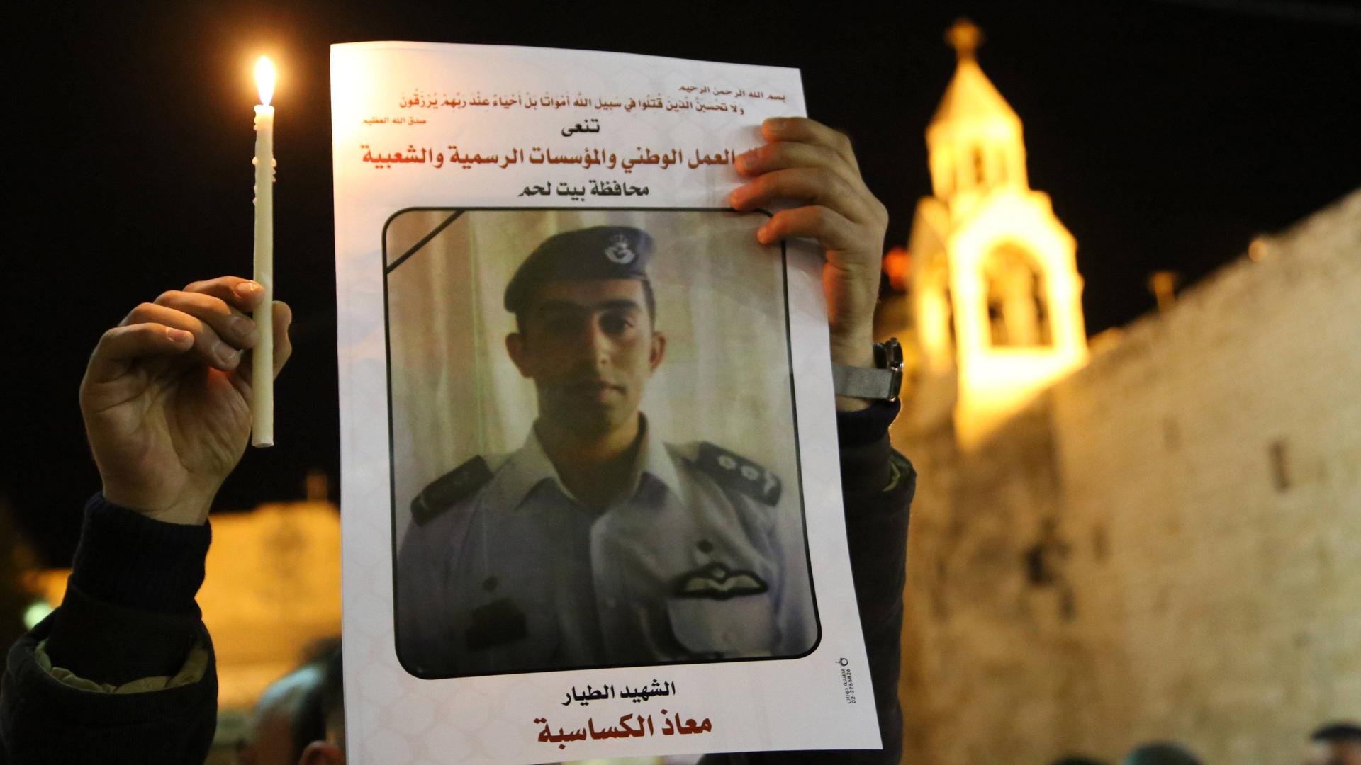 Ein Palästinenser hält am 05.02.2015 in Bethlehem eine Kerze und ein Portrait von dem vom IS ermordeten jordanischen Piloten Muath al-Kasasbeh in den Händen. Ein Palästinenser hält am 05.02.2015 in Bethlehem eine Kerze und ein Portrait von dem vom IS ermordeten jordanischen Piloten Muath al-Kasasbeh in den Händen.