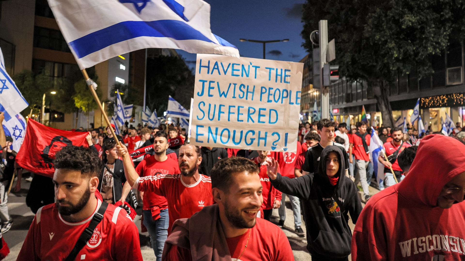 Demonstranten schwenken israelische Flaggen und halten Plakate hoch. Demonstranten schwenken israelische Flaggen und halten Plakate hoch.