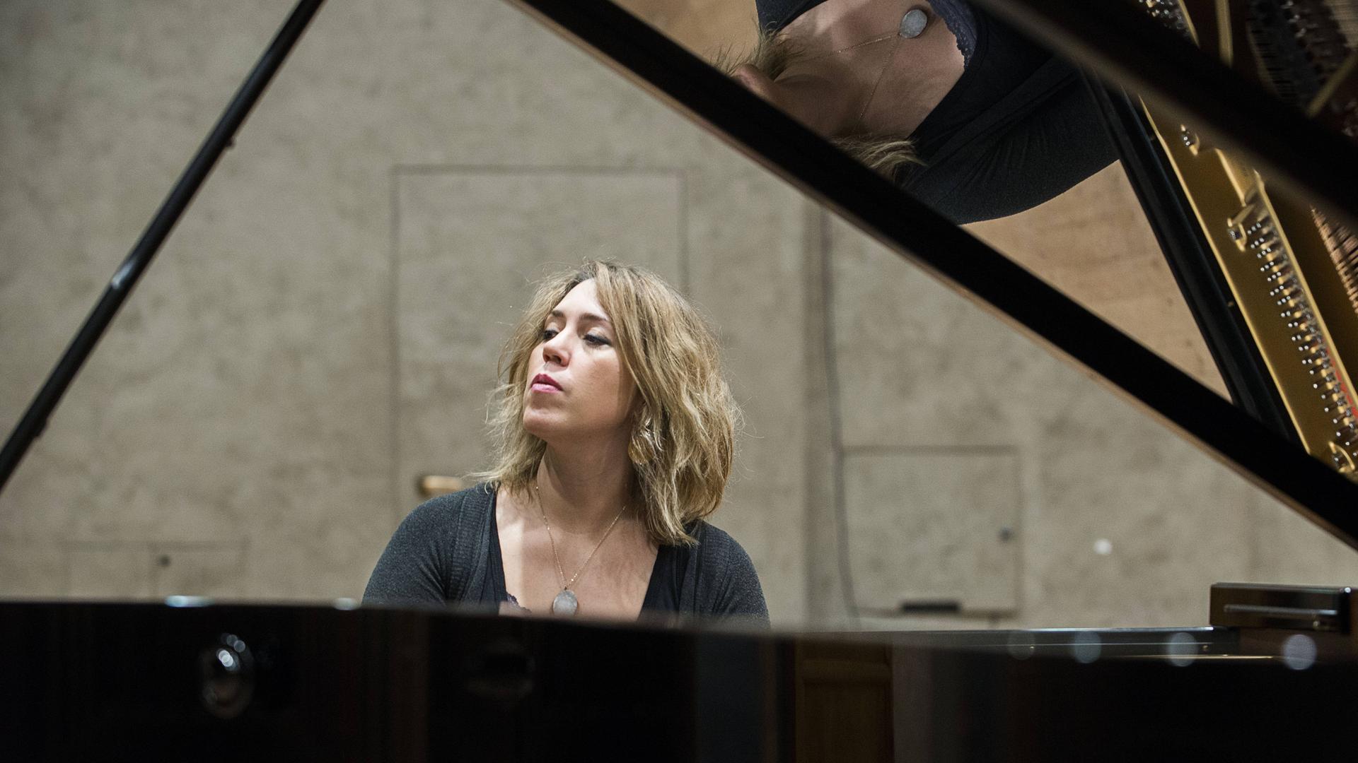 Wir sehen eine Frau, die Klavier spielt. Wir sehen eine Frau, die Klavier spielt.