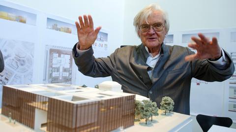 Der Architekt Meinhard von Gerkan erhebt die Hände wie ein Dirigent über einem Modell für dem Neubau der Kunsthalle Mannheim.