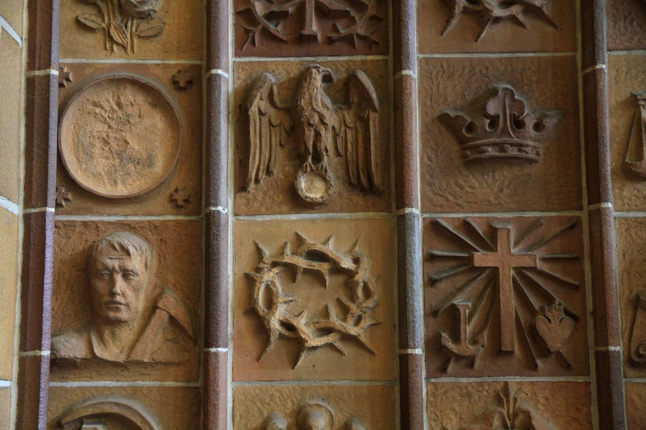 Terrakotten in der Martin-Luther-Gedächtniskirche Berlin zeigen ein Kreuz, eine Krone, einen Reichsadler und andere Symbole. Terrakotten in der Martin-Luther-Gedächtniskirche Berlin zeigen ein Kreuz, eine Krone, einen Reichsadler und andere Symbole.
