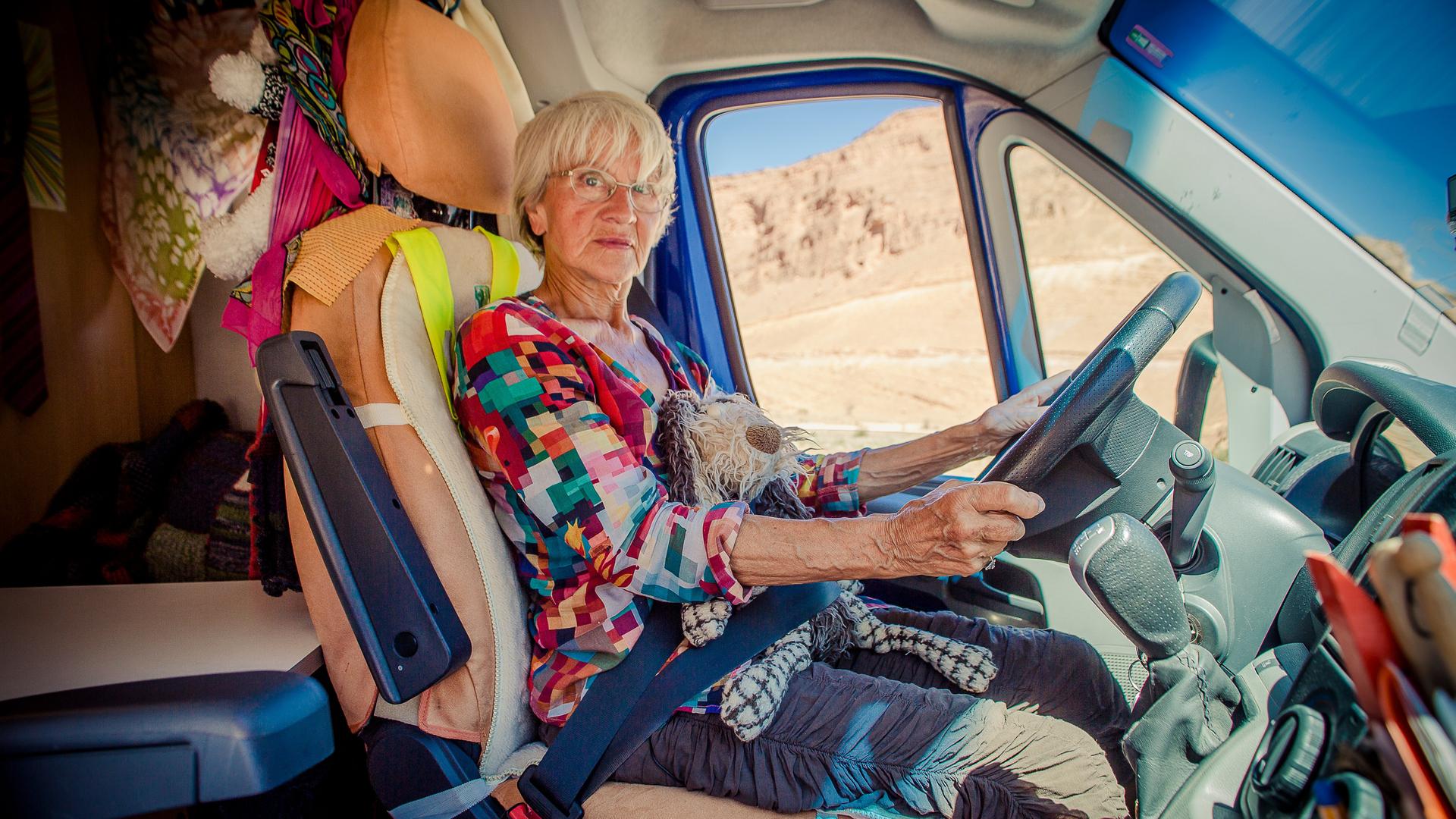 Gisela sitzt am Steuer Ihres Kleintransporters und schaut Richtung Betrachter. Gisela sitzt am Steuer Ihres Kleintransporters und schaut Richtung Betrachter.