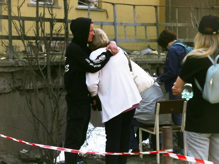Ein Mann und eine Frau halten sich nach einem Raketenangriff in Kiew in den Armen und trauern um ein getötetes Kind