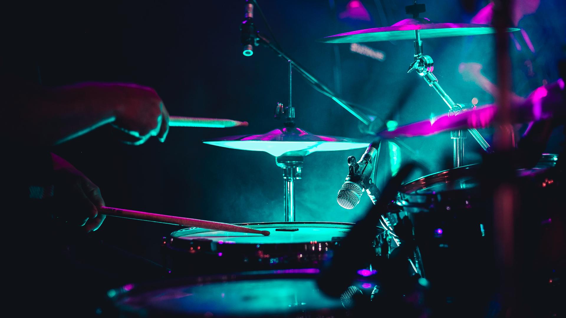 Nahaufnahme eines Drumsets in neonfarbener Bühnenbeleuchtung. Nahaufnahme eines Drumsets in neonfarbener Bühnenbeleuchtung.