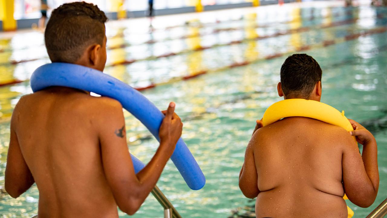 Zwei Kinder stehen im Stadtbad Märkisches Viertel in Berlin mit einer Schwimmnudel am Beckenrand.