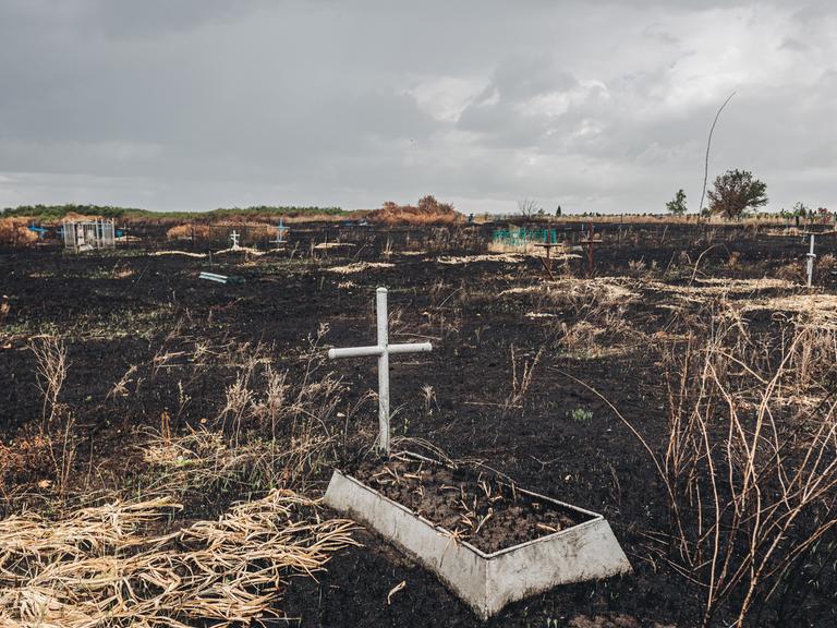 Ein Grab mit einem Kreuz im Kampfgebiet im Osten der Ukraine 
