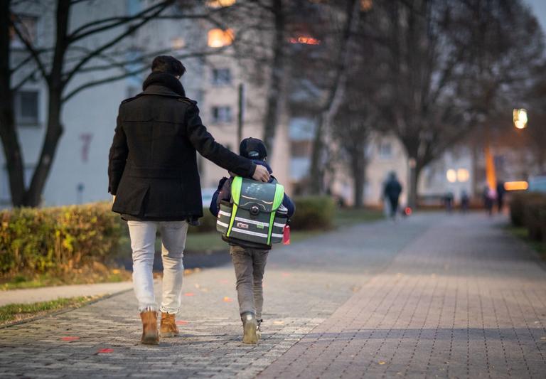 A father accompanies his son on the way to school.