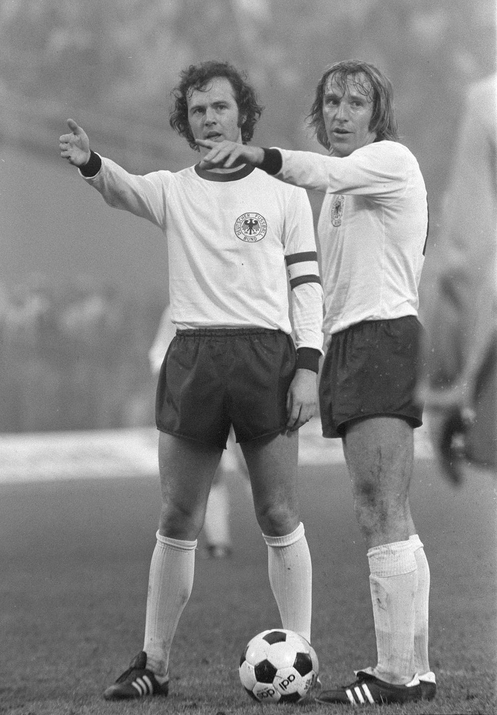 Franz Beckenbauer (links) und Günter Netzer gestikulieren im Spiel der deutschen Fußball-Nationalmannschaft gegen Schweden im Jahr 1974.