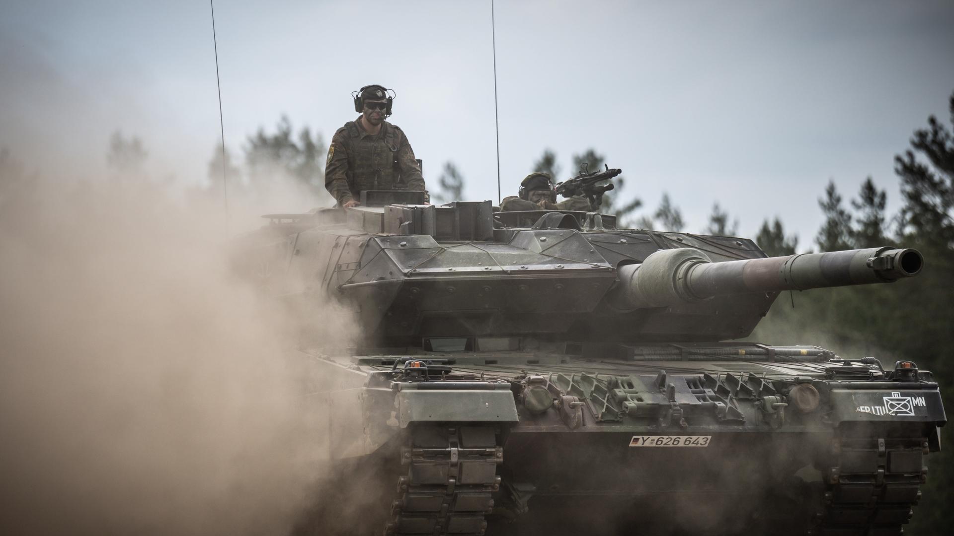Ein Leopard-2-Panzer der Bundeswehr, der von der NATO Enhanced Forward Presence Battle Group (eFP-Bataillon) eingesetzt wird, fährt beim Besuch von Bundeskanzler Scholz durch das Camp Adrian Rohn