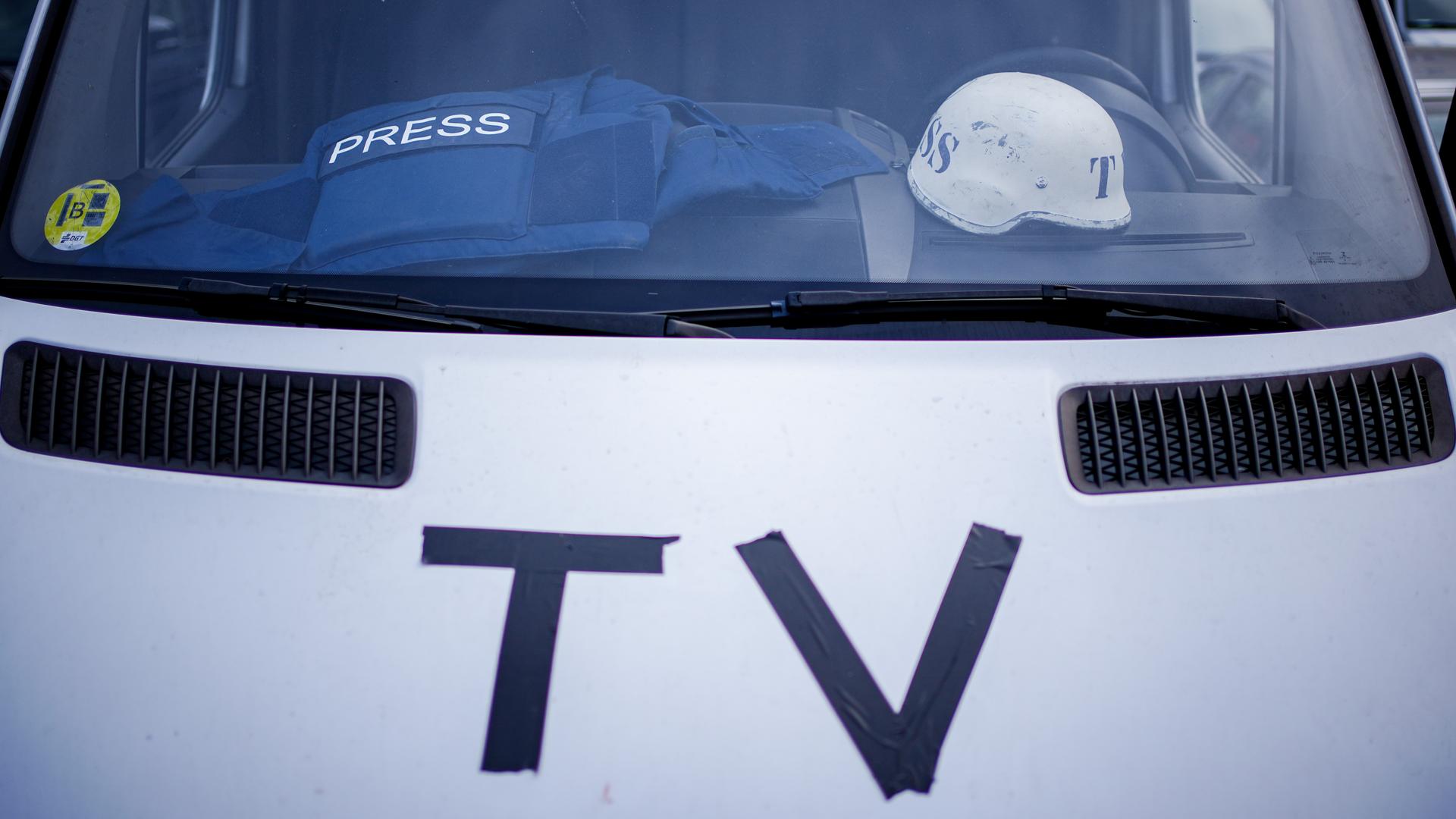 Auf dem Armaturenbrett eines Fernsehübertragungswagens vor dem Bahnhof von Przemysl nahe der ukrainisch–polnischen Grenze liegen eine Splitterschutzweste und ein Helm.