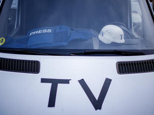 Auf dem Armaturenbrett eines Fernsehübertragungswagens vor dem Bahnhof von Przemysl nahe der ukrainisch–polnischen Grenze liegen eine Splitterschutzweste und ein Helm.
