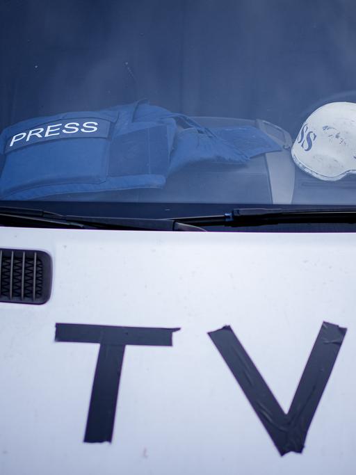 Auf dem Armaturenbrett eines Fernsehübertragungswagens vor dem Bahnhof von Przemysl nahe der ukrainisch–polnischen Grenze liegen eine Splitterschutzweste und ein Helm.